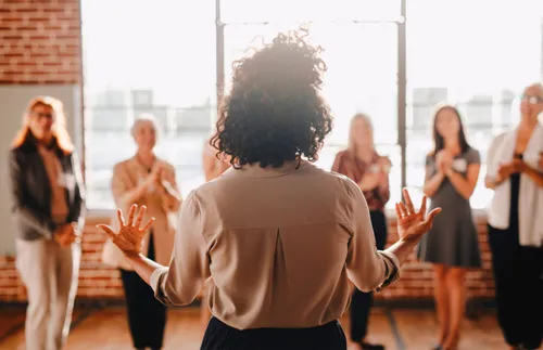 a woman standing in front of a group of people