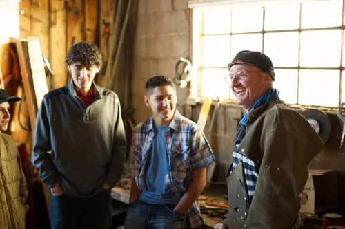 A group of young men go to visit an elderly man on his farm or ranch.