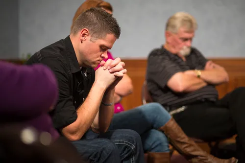 Men and women meeting together in an addiction recovery program.