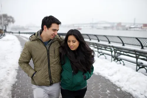 young couple walking on path surrounded by snow