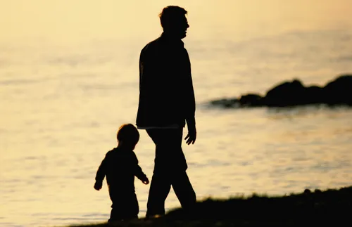 father and son walking on a beach