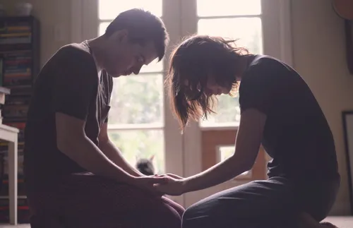 a couple holding hands and praying