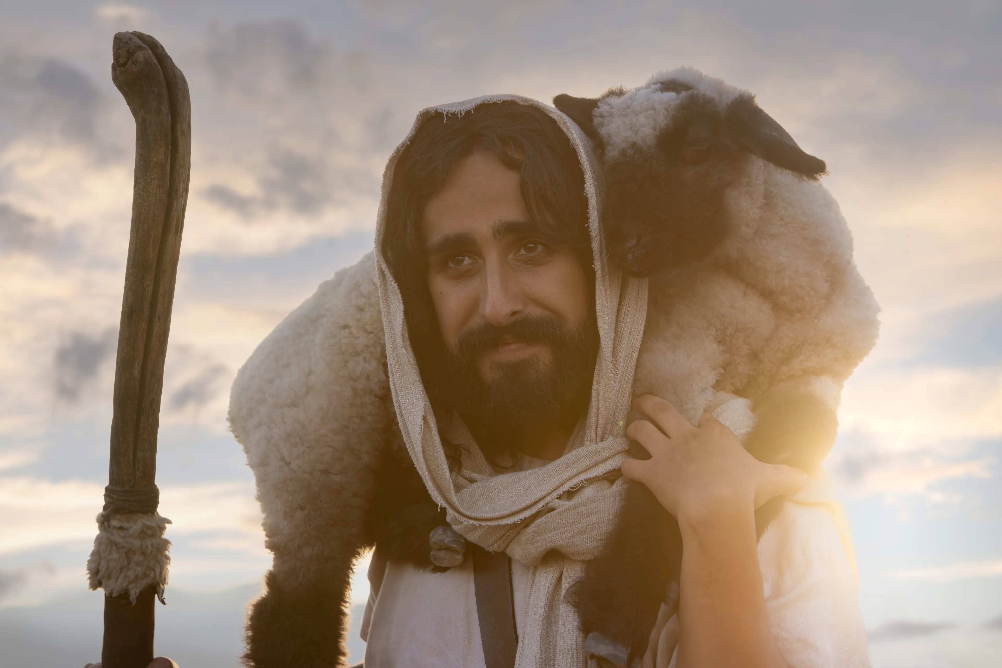 Close up depiction of Jesus Christ carrying a lamb across his shoulders and holding a shepherds staff. Detail from the Easter 2026 campaign. © undefined ipCode 1.