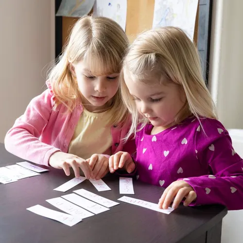 Two girls putting strips of paper in order