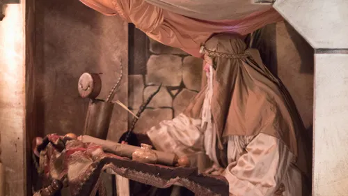 a man sitting at a desk writing on scrolls