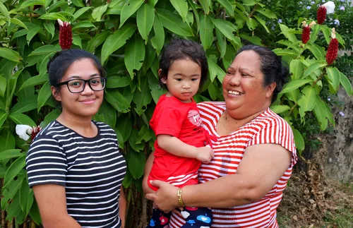 two women standing together with a child