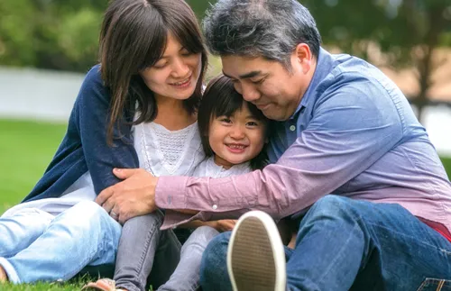 mother and father hugging their toddler