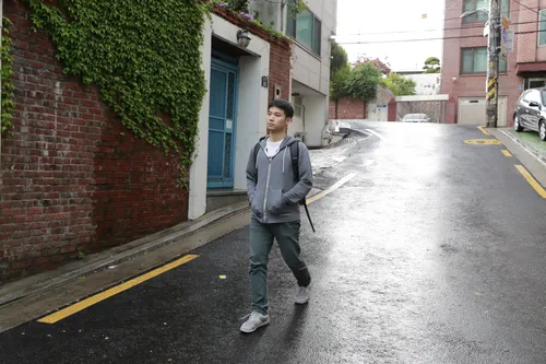 young man walking through a city