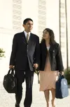 An Hispanic couple with temple bags walking outside the Los Angeles California Temple.