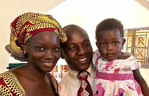 a mother and father and their little girl