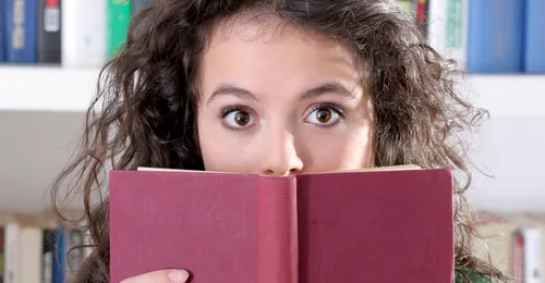 young woman holding up book