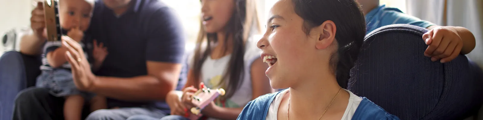 Series of images of family spending time together and female child playing the guitar/ukelele