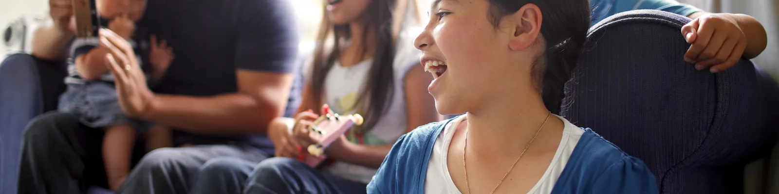 Series of images of family spending time together and female child playing the guitar/ukelele