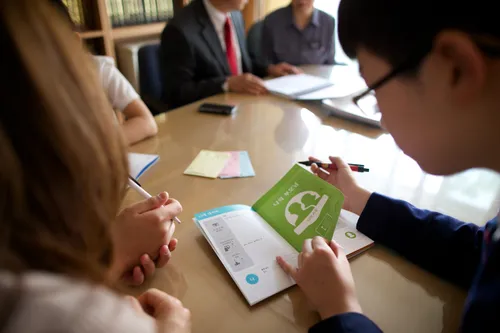 man writing in booklet