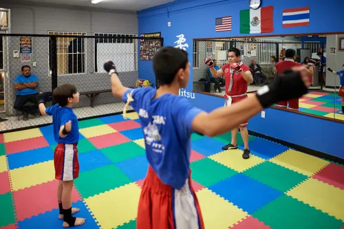 man leading young men in exercises in a gym