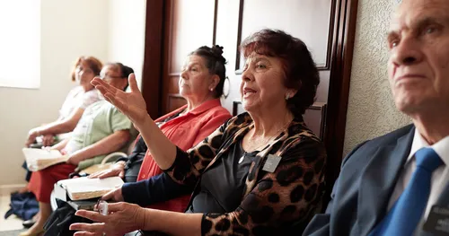 Woman raises hand in adult Sunday School class.
