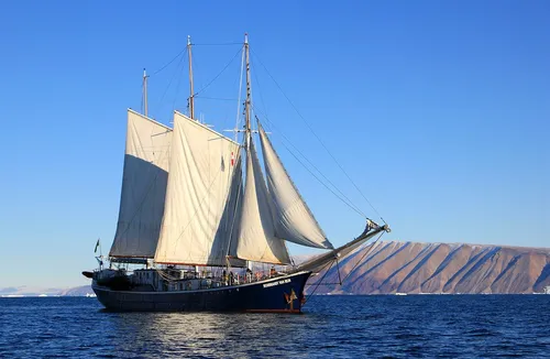 sailboat on the ocean, with mountain in the background