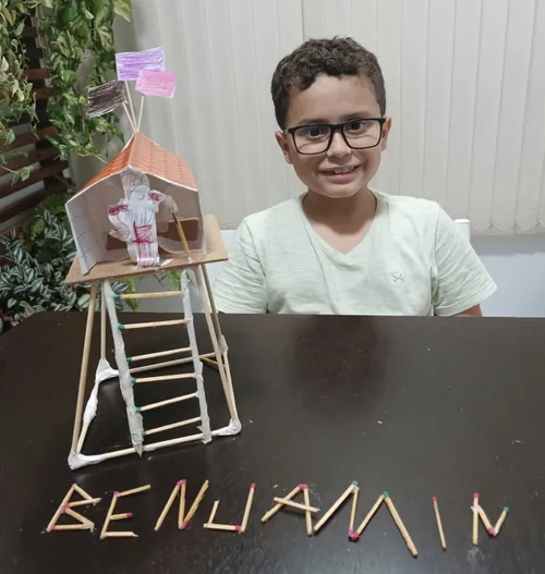 boy with tower build out of sticks