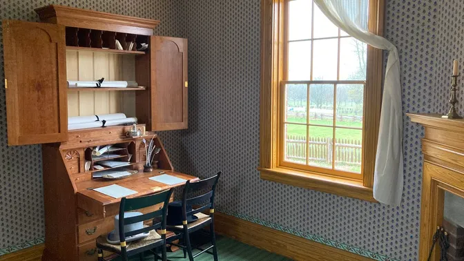 Home office setting with two chairs in front of a secretary desk.