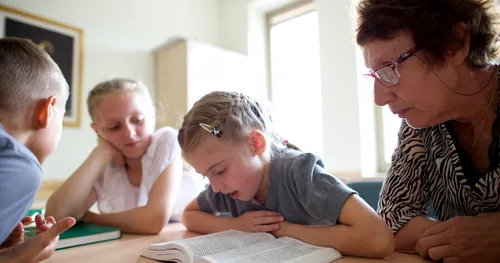 child reading scriptures in class