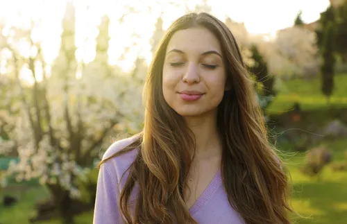 young woman closing her eyes in nature