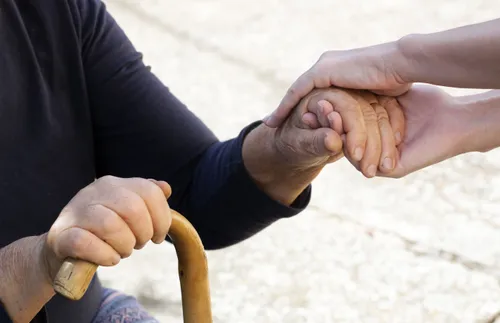 one person’s hands holding another person’s hand