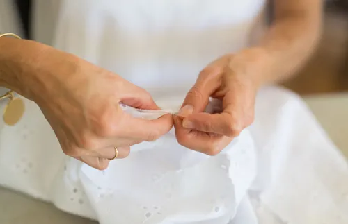 hands stitching a dress