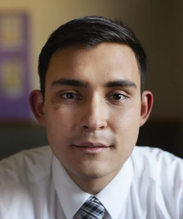 A missionary models appropriate shirts and ties and he smiles and talks to someone off camera.