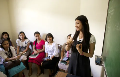 young woman standing in front of class