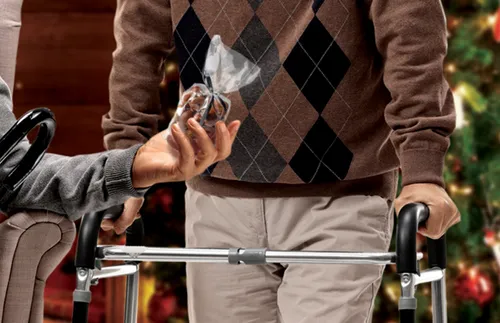 man handing a gift to a man using a walker