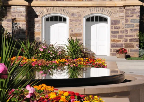 A pool of water on the grounds of the Logan Utah Temple, near two white doors leading inside the temple.