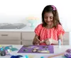 Girl gluing pictures onto a paper