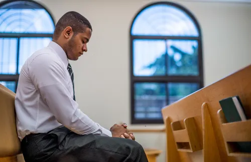 a man sitting in a pew and praying