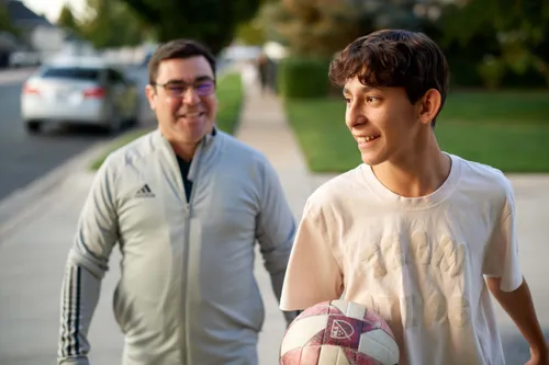 a father and his son walking down the street