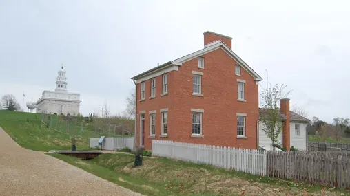 A two-story brick home with a single-story white clapboard addition.