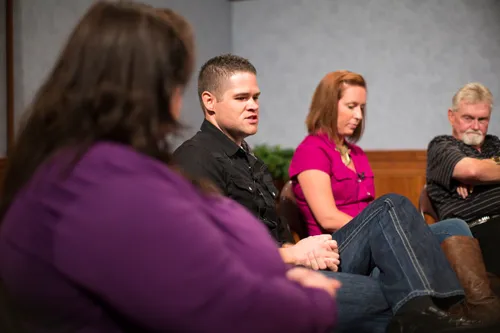 Men and women meeting together in an addiction recovery program.