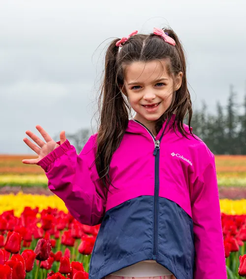 Girl waving in tulip field