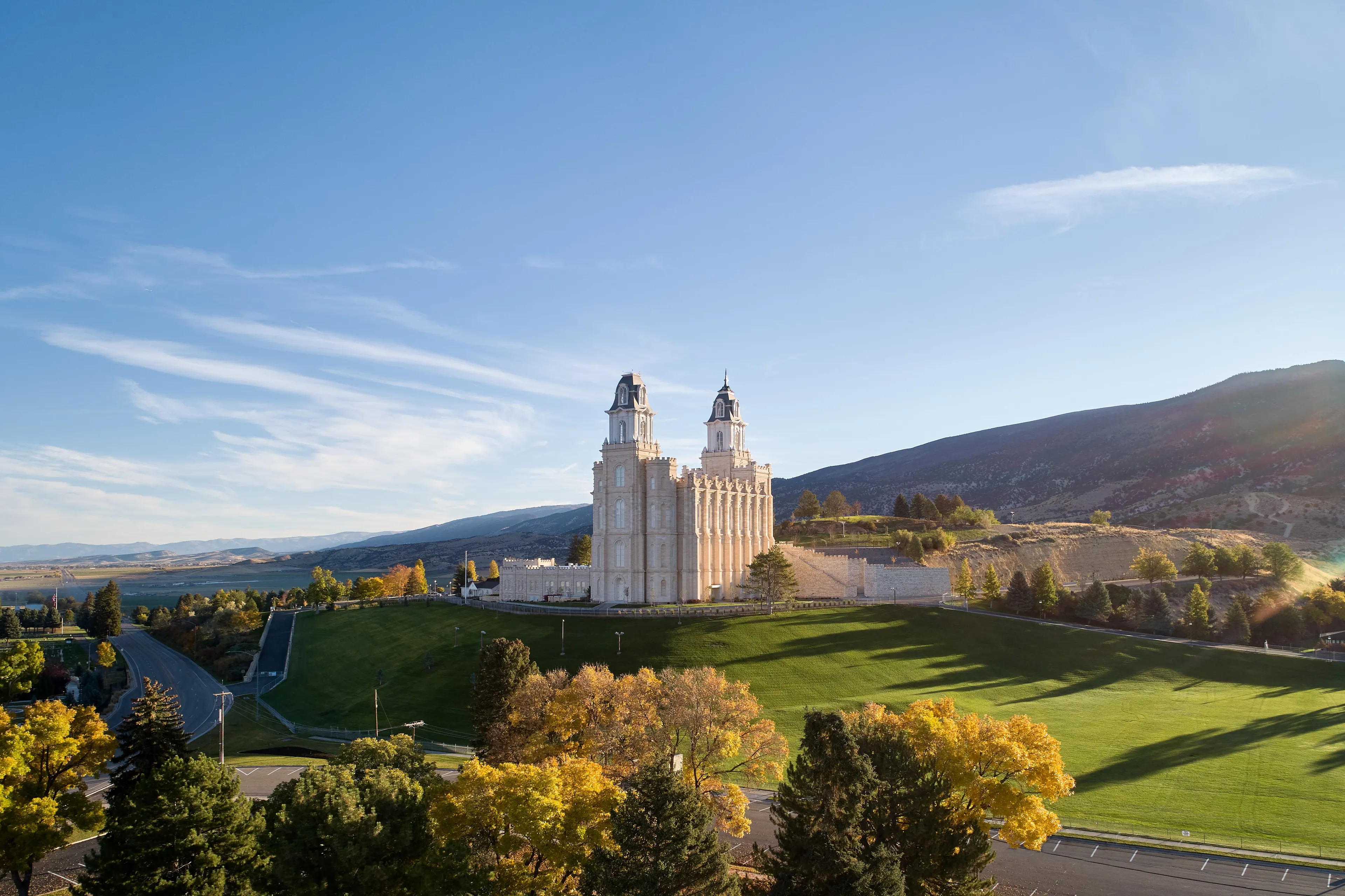 Exterior image of the Manti Utah Temple highlighting the temple itself and the surrounding temple grounds. The image is taken during the day.