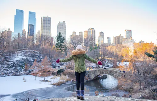 woman standing with open arms at park