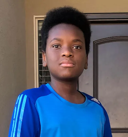 boy standing outside his house