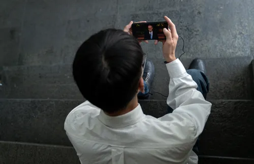 a young adult man watching general conference