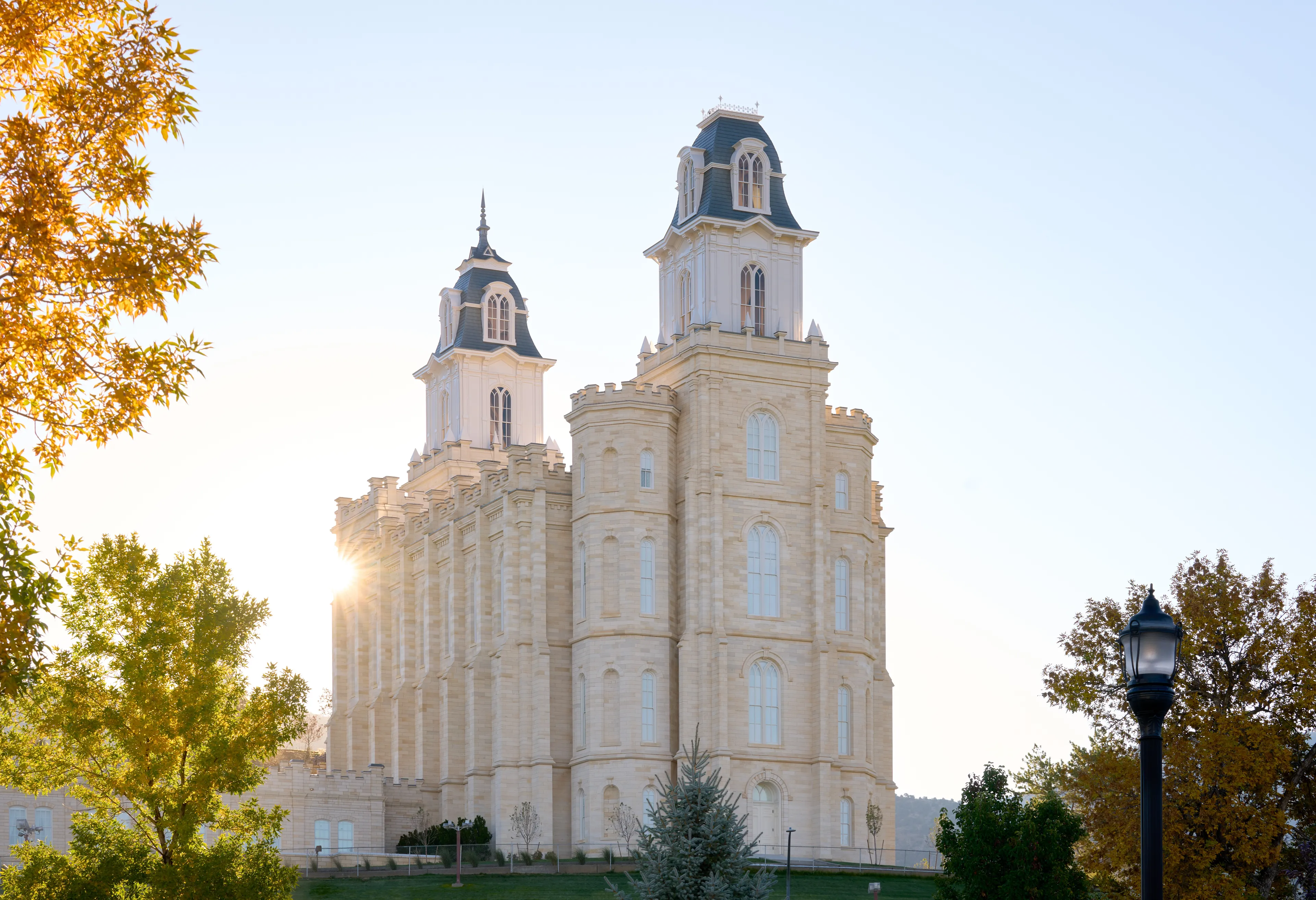 Exterior image of the Manti Utah Temple highlighting the temple itself and the surrounding temple grounds. The image is taken during the day.