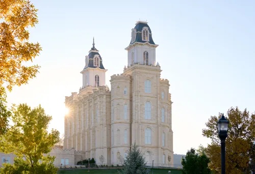 Exterior image of the Manti Utah Temple highlighting the temple itself and the surrounding temple grounds. The image is taken during the day.