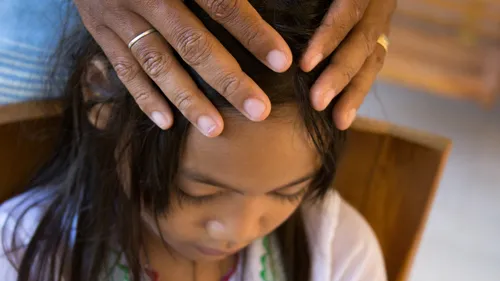 young girl receiving a blessing