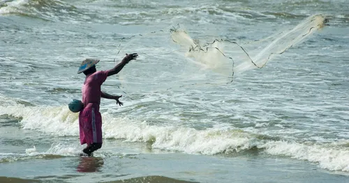 撒網捕魚的男子