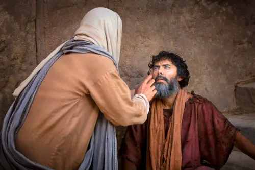 Christ with His hand outstretched, healing a blind man, who is sitting down.