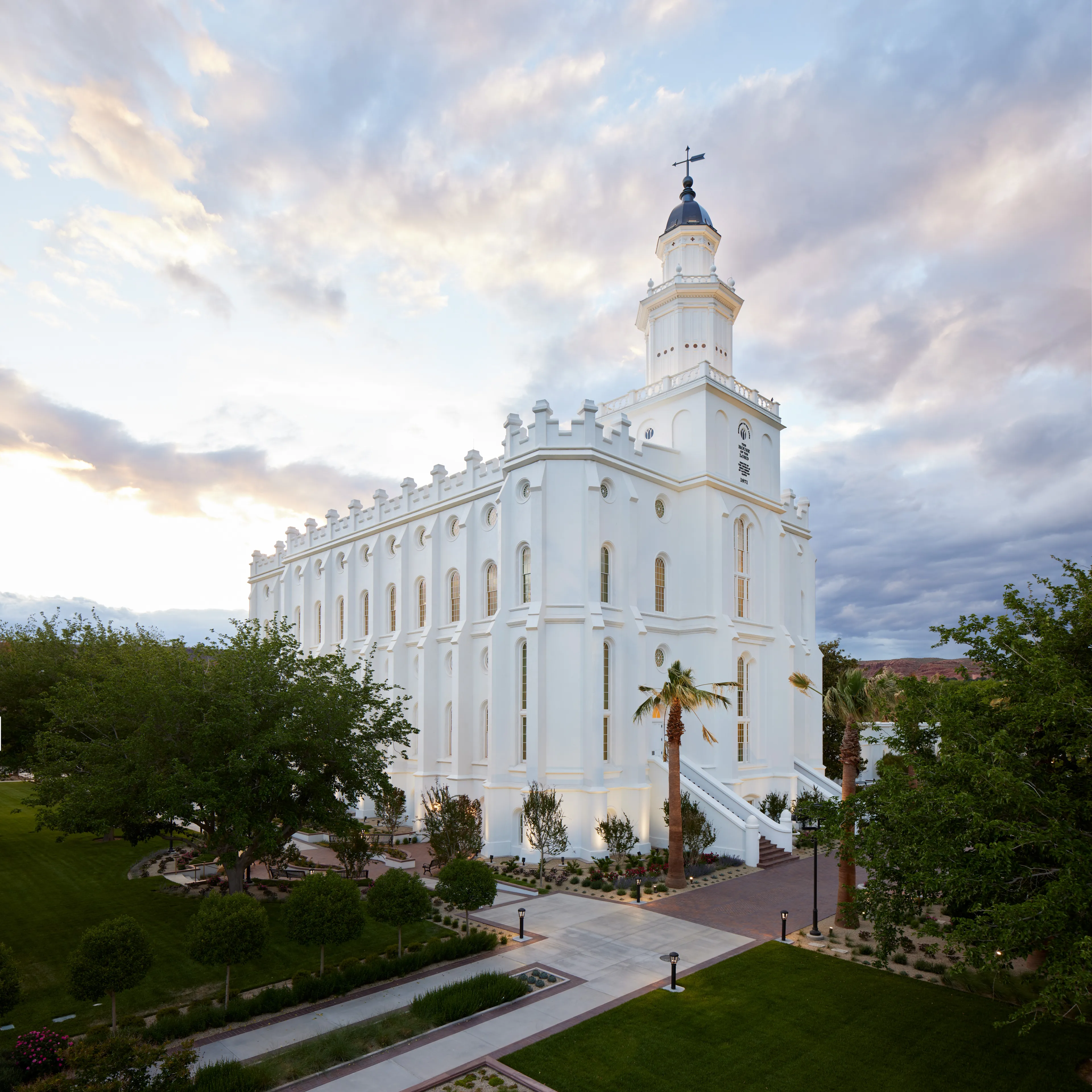 Exterior image of the St. George Utah Temple. The image features the temple set around trees surrounding the temple grounds. 