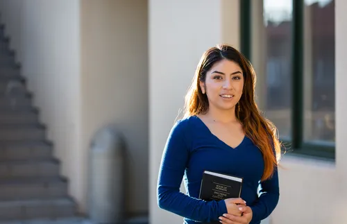 young woman holding Book of Mormon