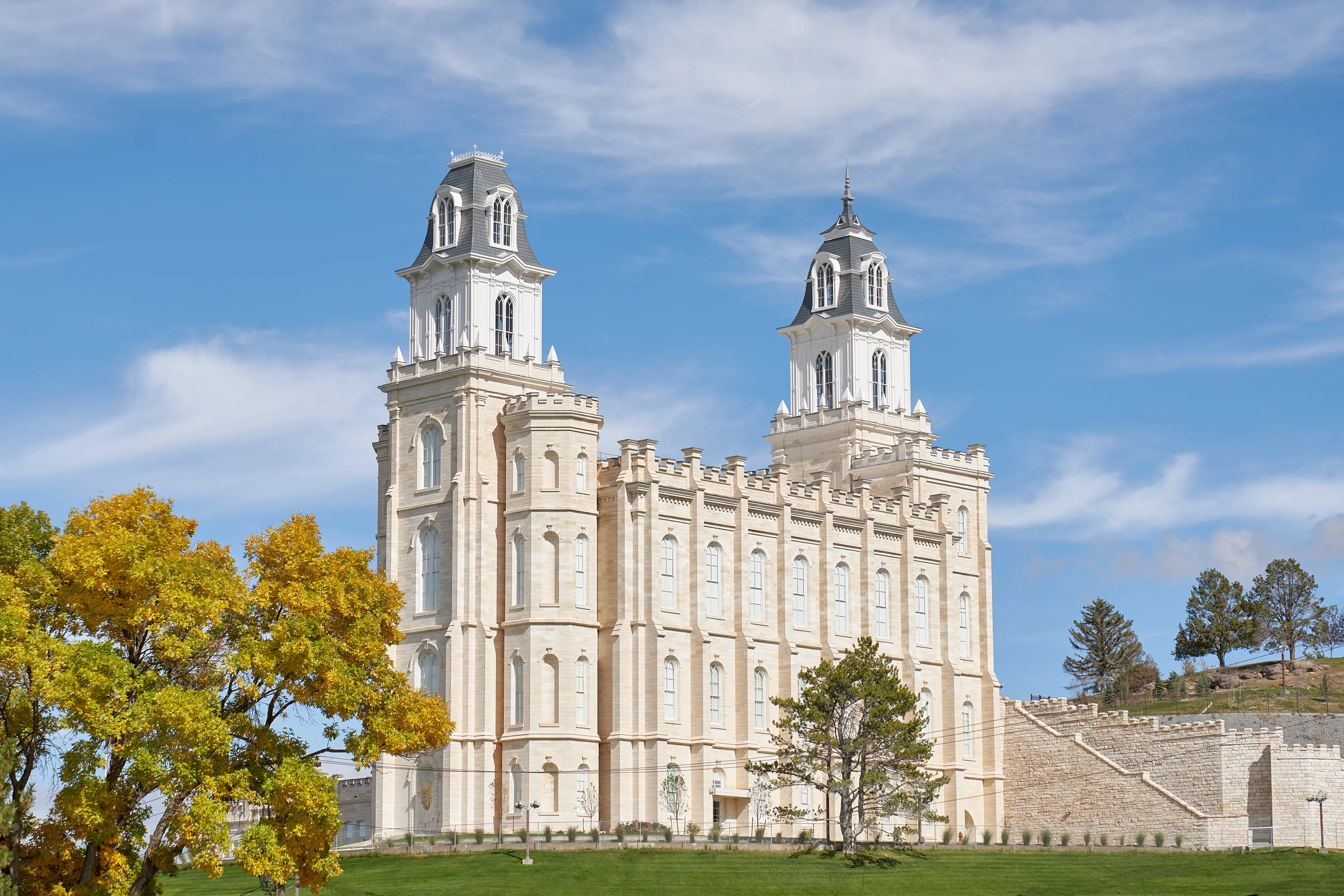 Exterior image of the Manti Utah Temple highlighting the temple itself and the surrounding temple grounds. The image is taken during the day.