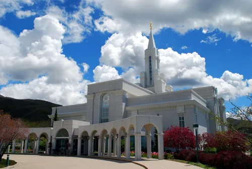 The front of the Bountiful Utah Temple in the daytime, with the arches at the temple’s entrance in view.